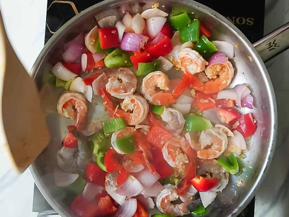 garlic shrimps/ prawns being sauteed in a pan