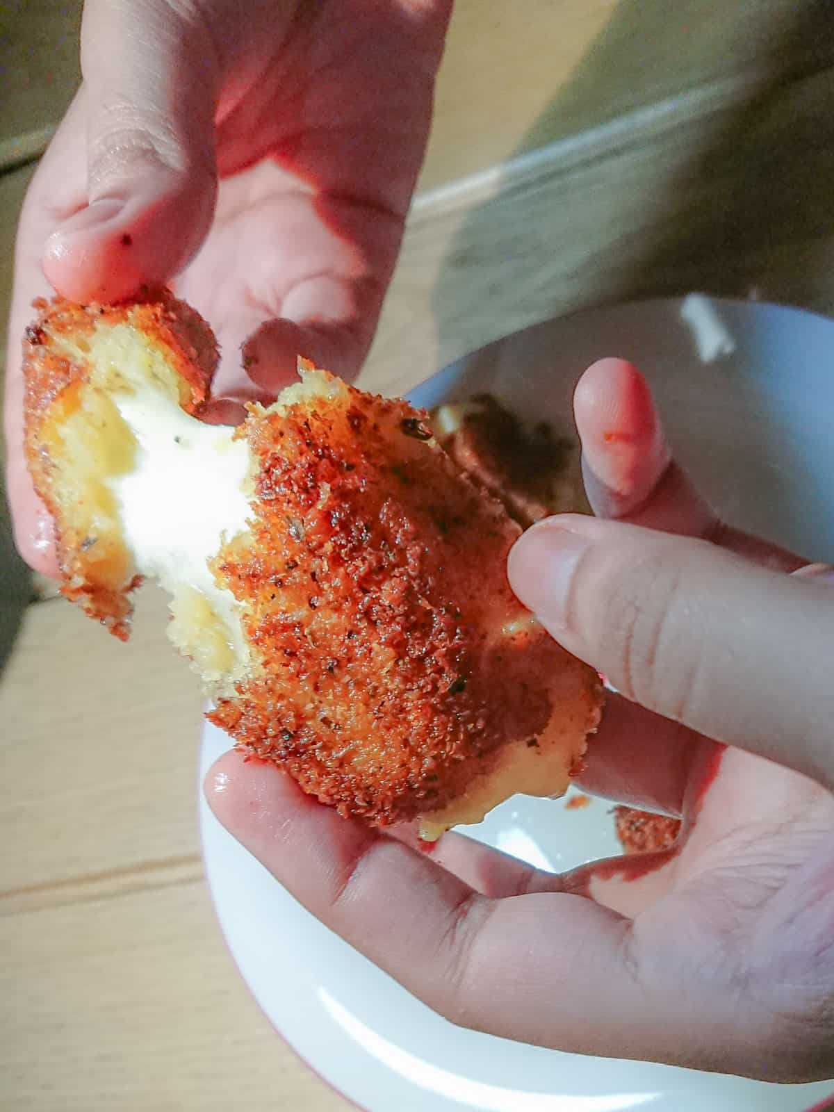 Hot cheese oozing out of crunchy potato croquettes.