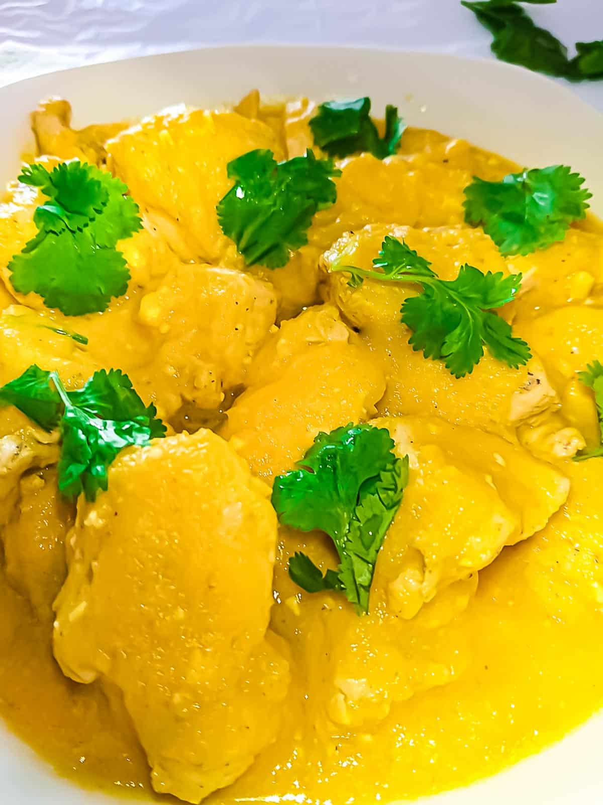 close-up view of lemon yogurt chicken on a white plate.