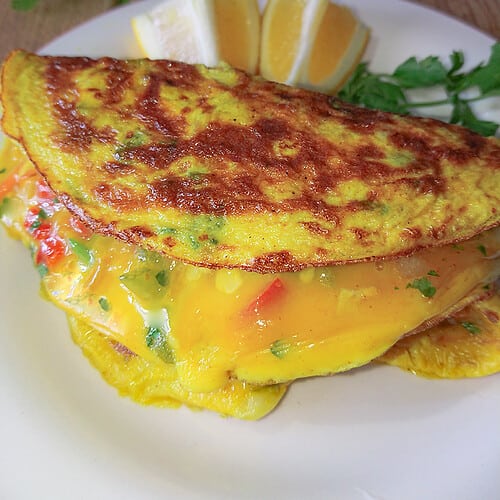 cabbage omelette with cheese on a white ceramic plate.