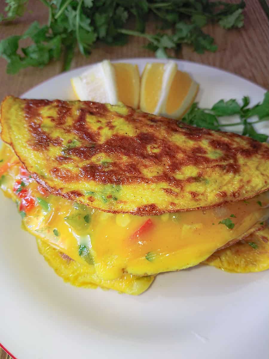 cabbage omelette with cheese on a white ceramic plate.