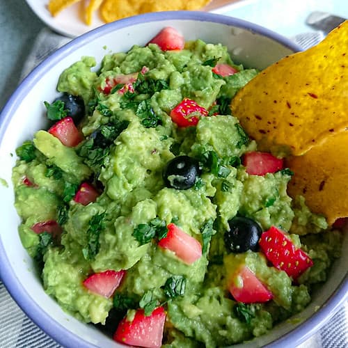 guacamole without onions in a bowl with tortilla chips.