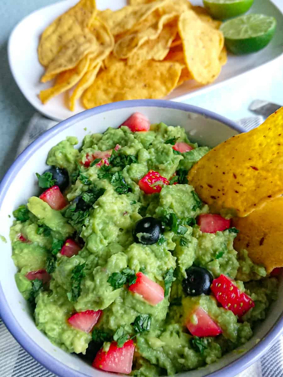 super simple guacamole without onions in a white bowl.