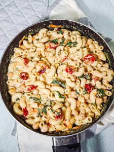 creamy vegetable pasta with vegan garlic sauce in a pan.