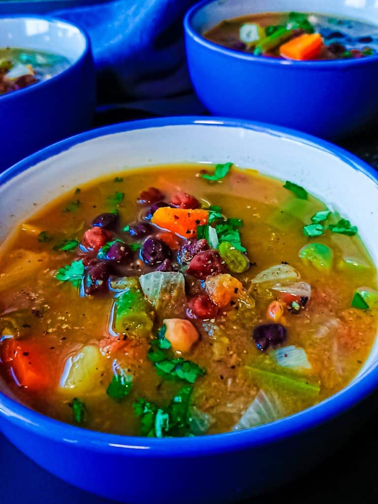 closeup view of black chana soup served in a ceramic bowl