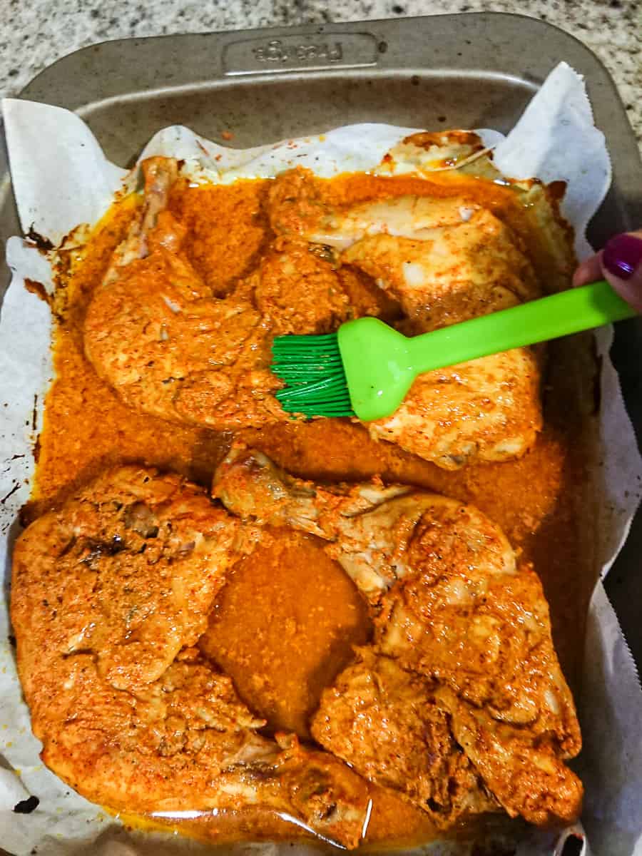 tandoori chicken in oven - basting the chicken legs with tandoori marinade