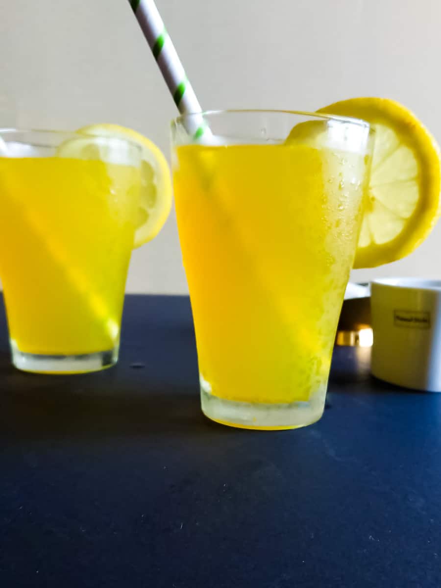 close-up view of chilled ginger turmeric juice in 2 tall glasses.