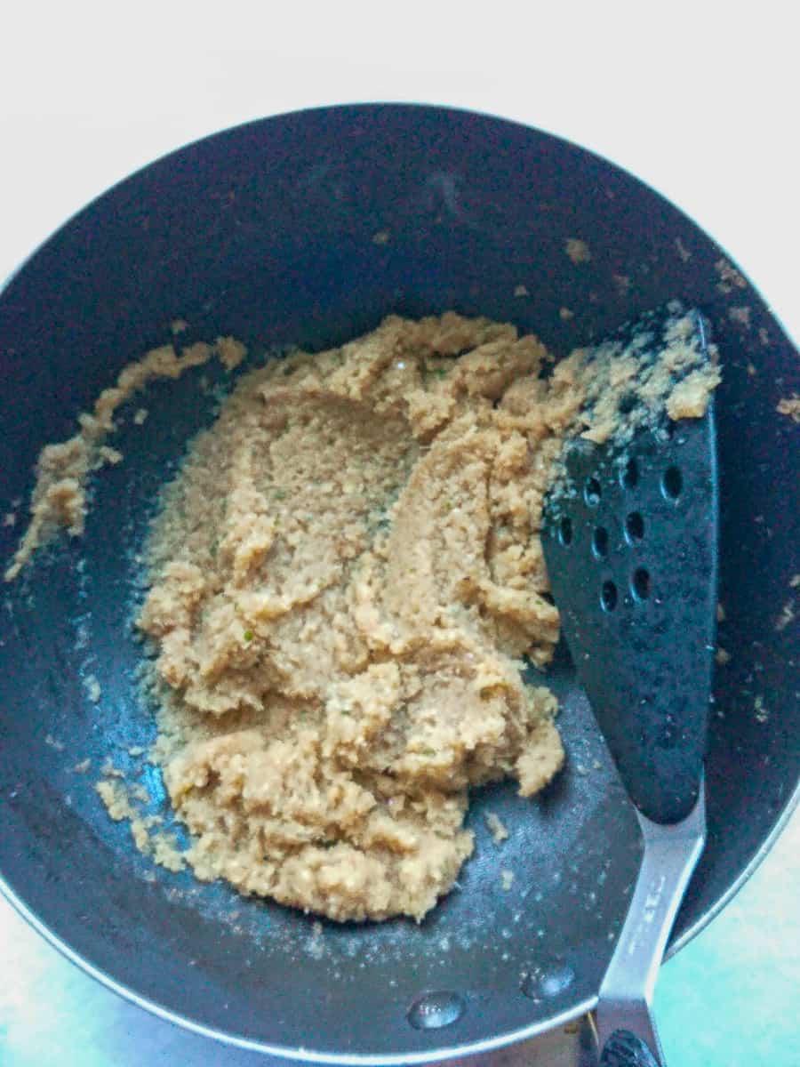 blended onions being sauteed in a wok pan.