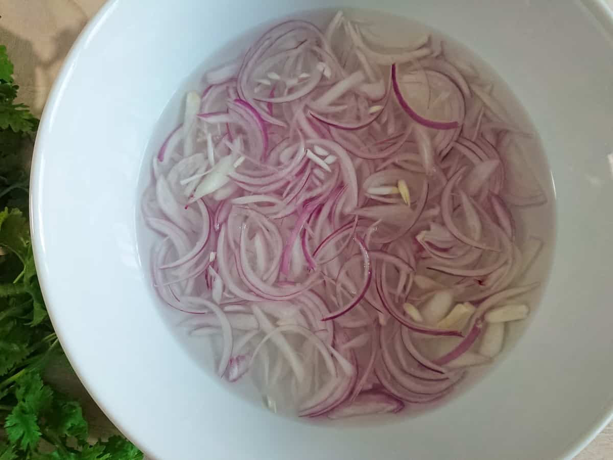 sliced onions being softened in salt water