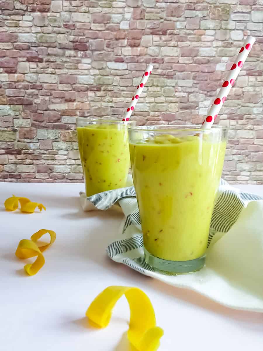 Dairy free mango smoothie without yogurt or banana in 2 tall glasses.
