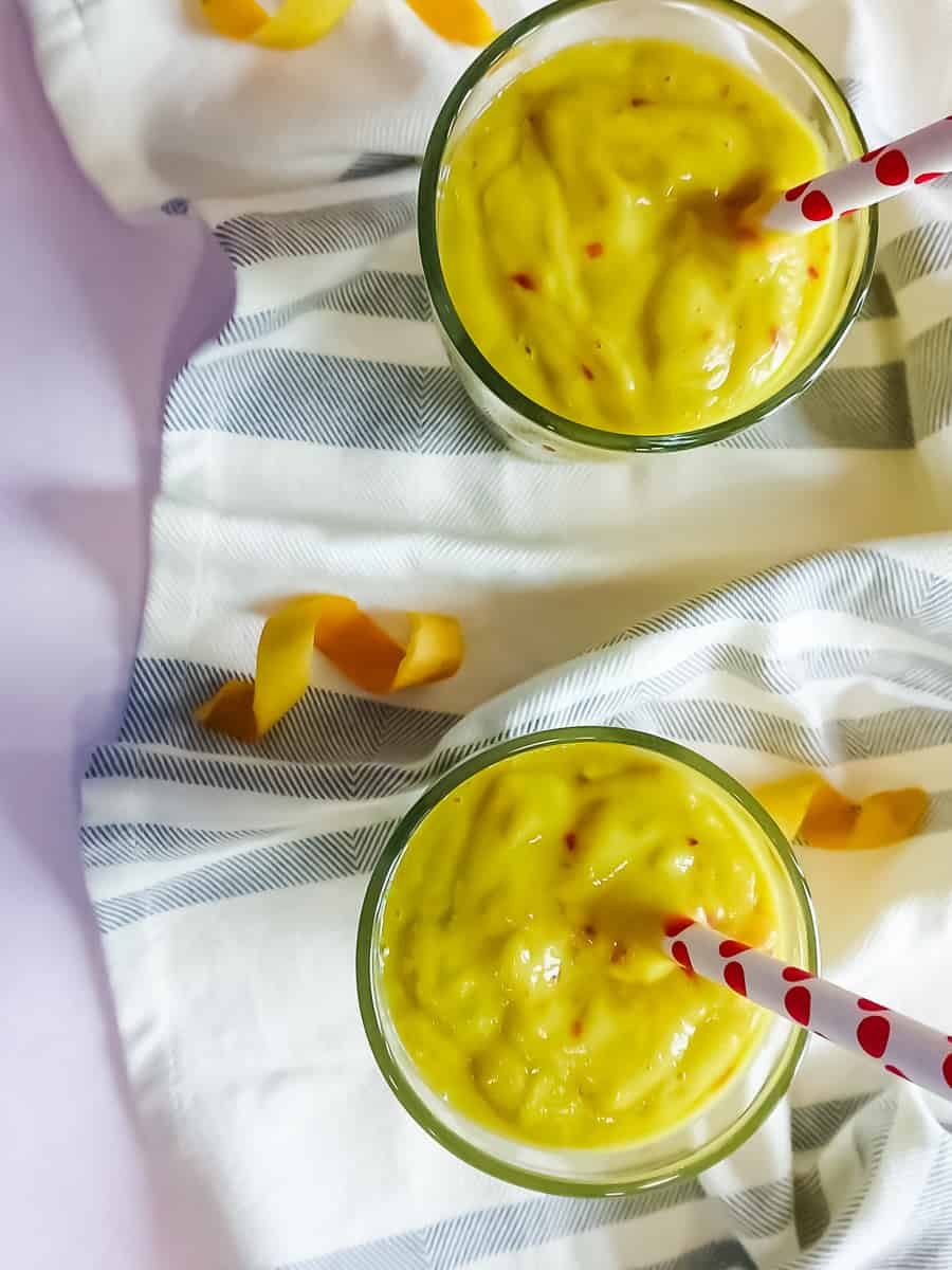 Avocado mango smoothie without yogurt in 2 tall glasses.