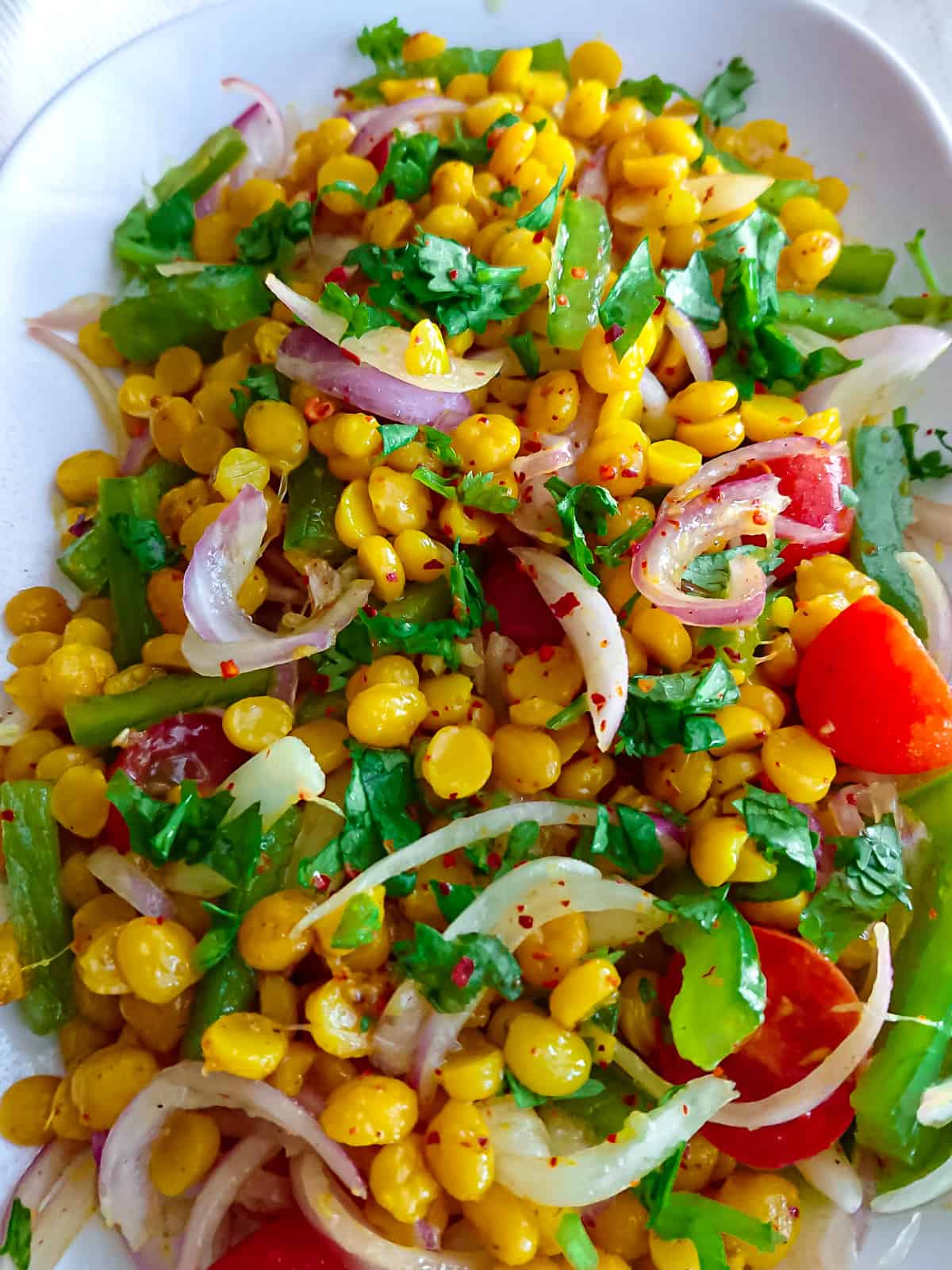 closeup view of yellow lentil salad with ginger lemon dressing on a white plate.