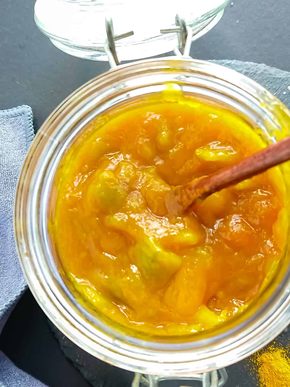 closeup view of raw mango chutney in a glass jar.