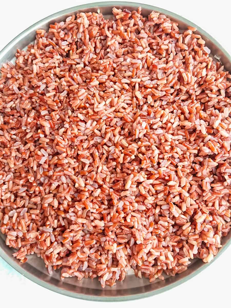 Stir-Fried Red Rice with Thai flavors cooked red rice spread out in a plate