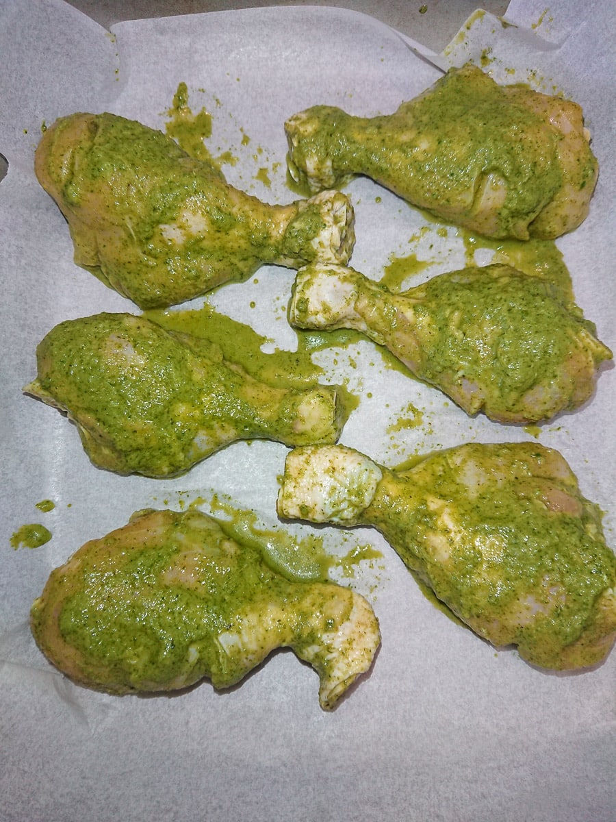 Easy Baked Pudina Chicken (Hariyali Chicken) marinated chicken drumsticks on a baking tray lined with baking paper