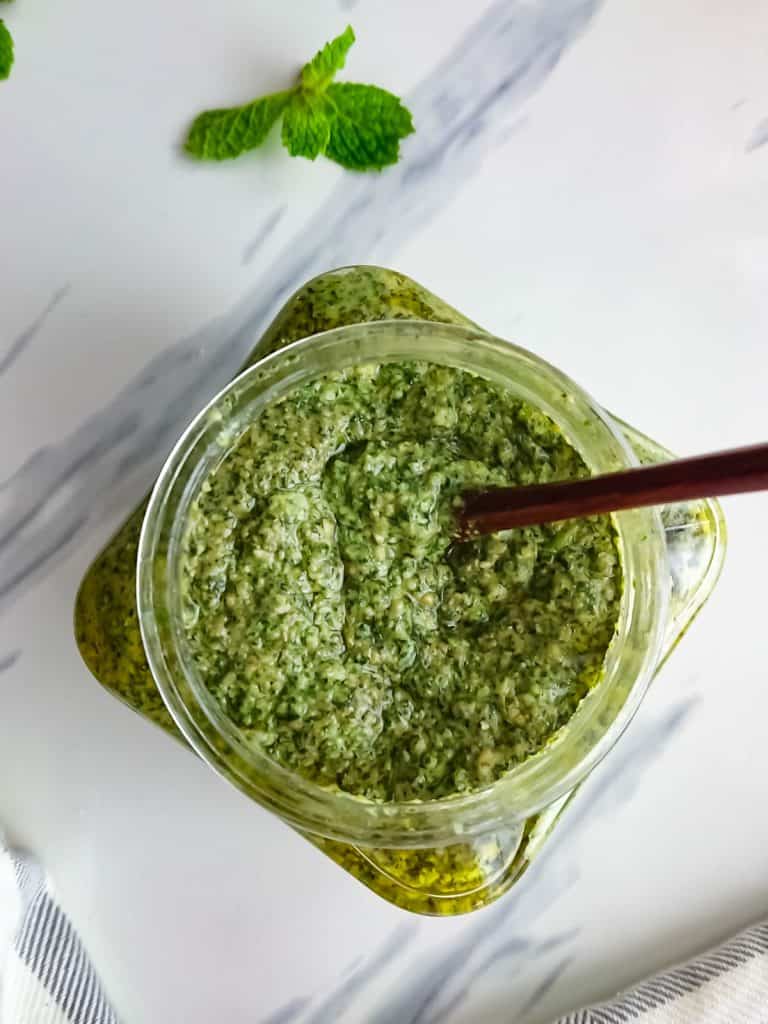 top view of roasted garlic Pesto with cashews in a glass jar.