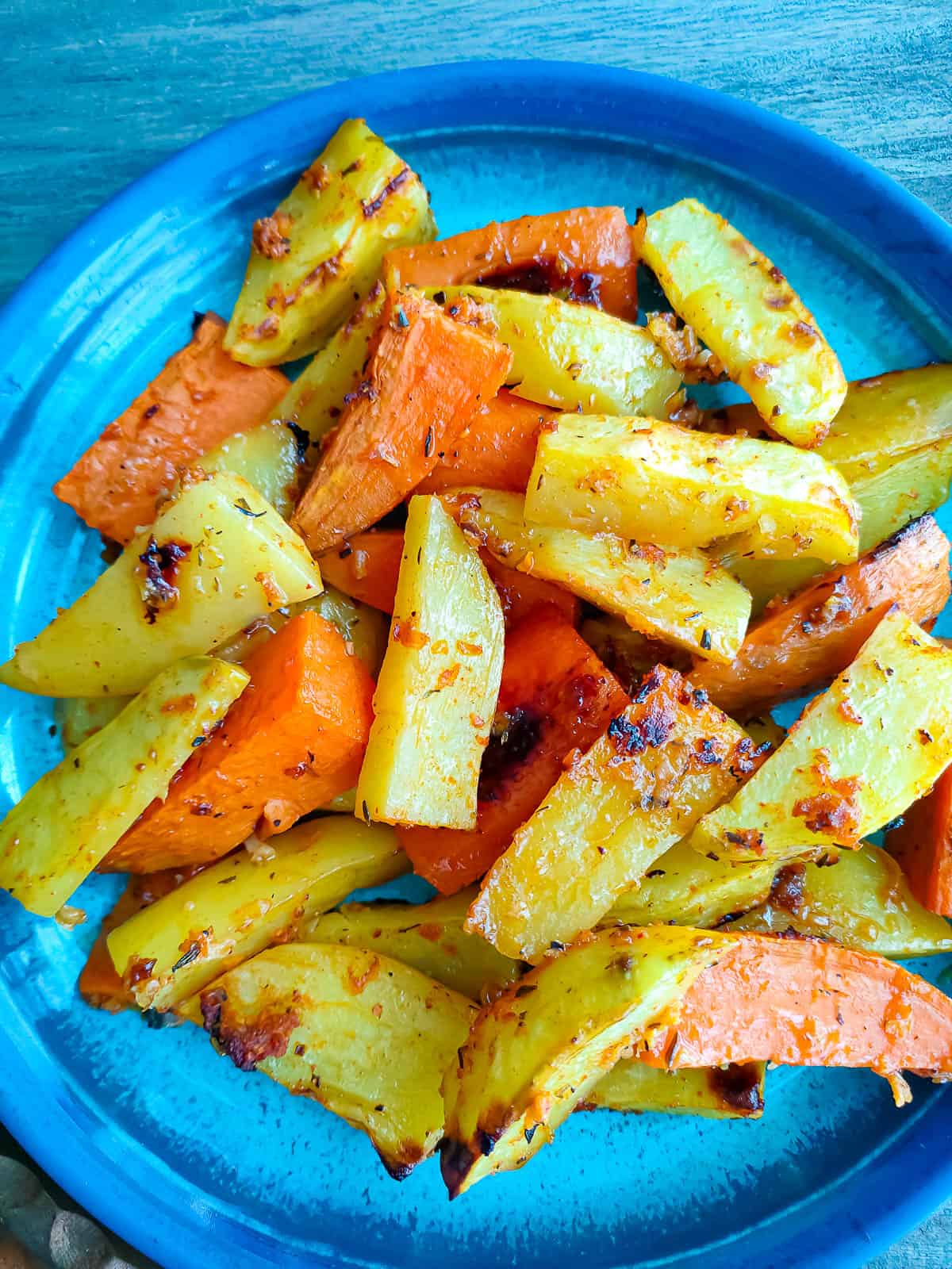 Lemon garlic roasted potatoes and sweet potatoes in a blue bowl.