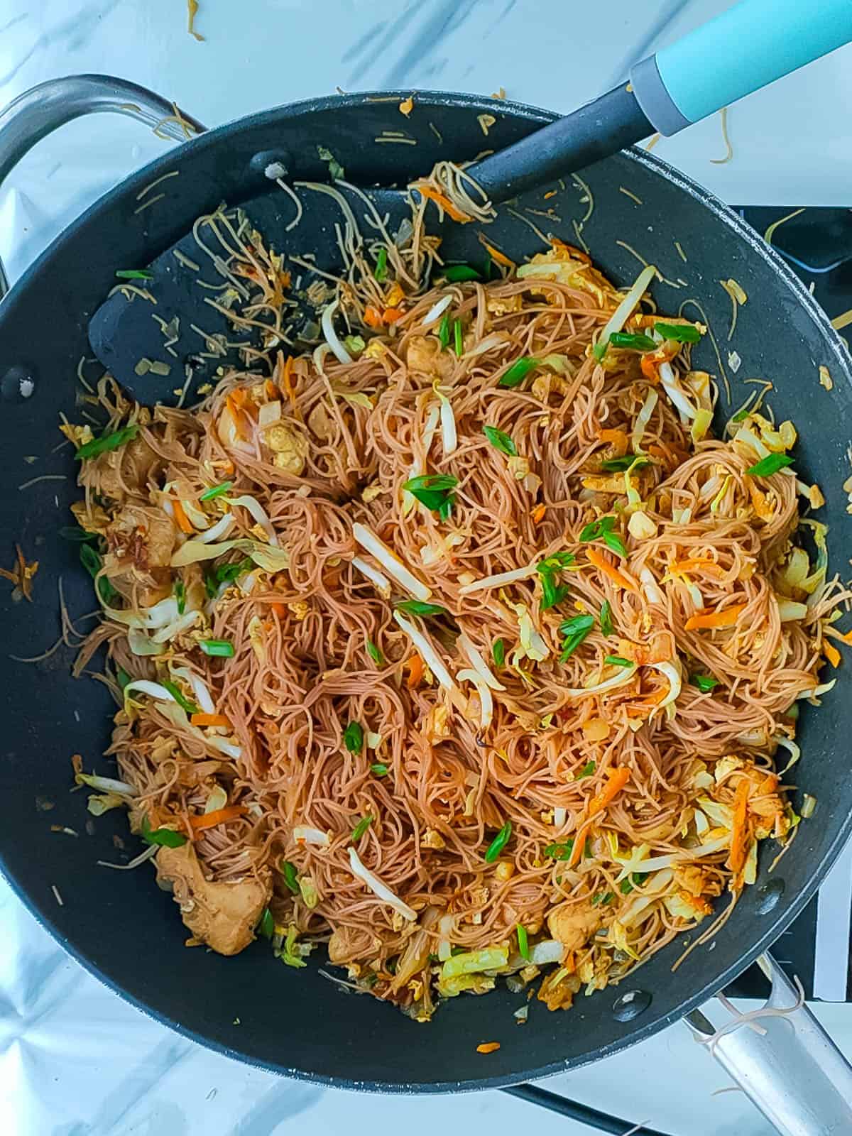 mee hoon goreng being stir-fried in a non-stick wok.