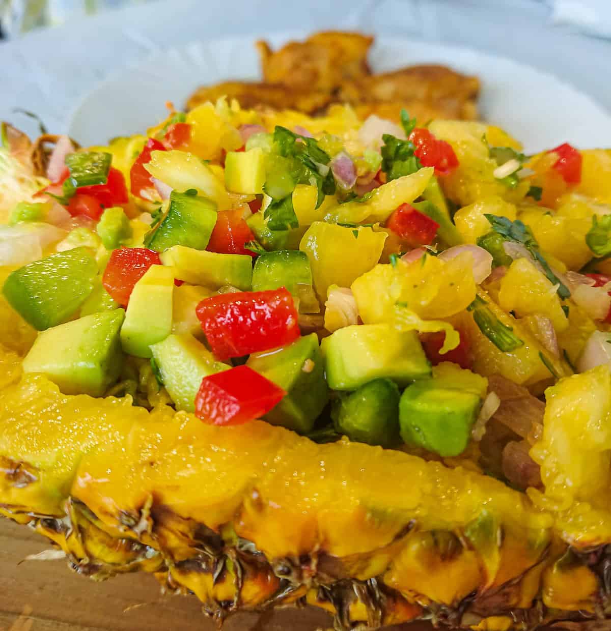 close-up view of pineapple avocado salsa in a pineapple boat.