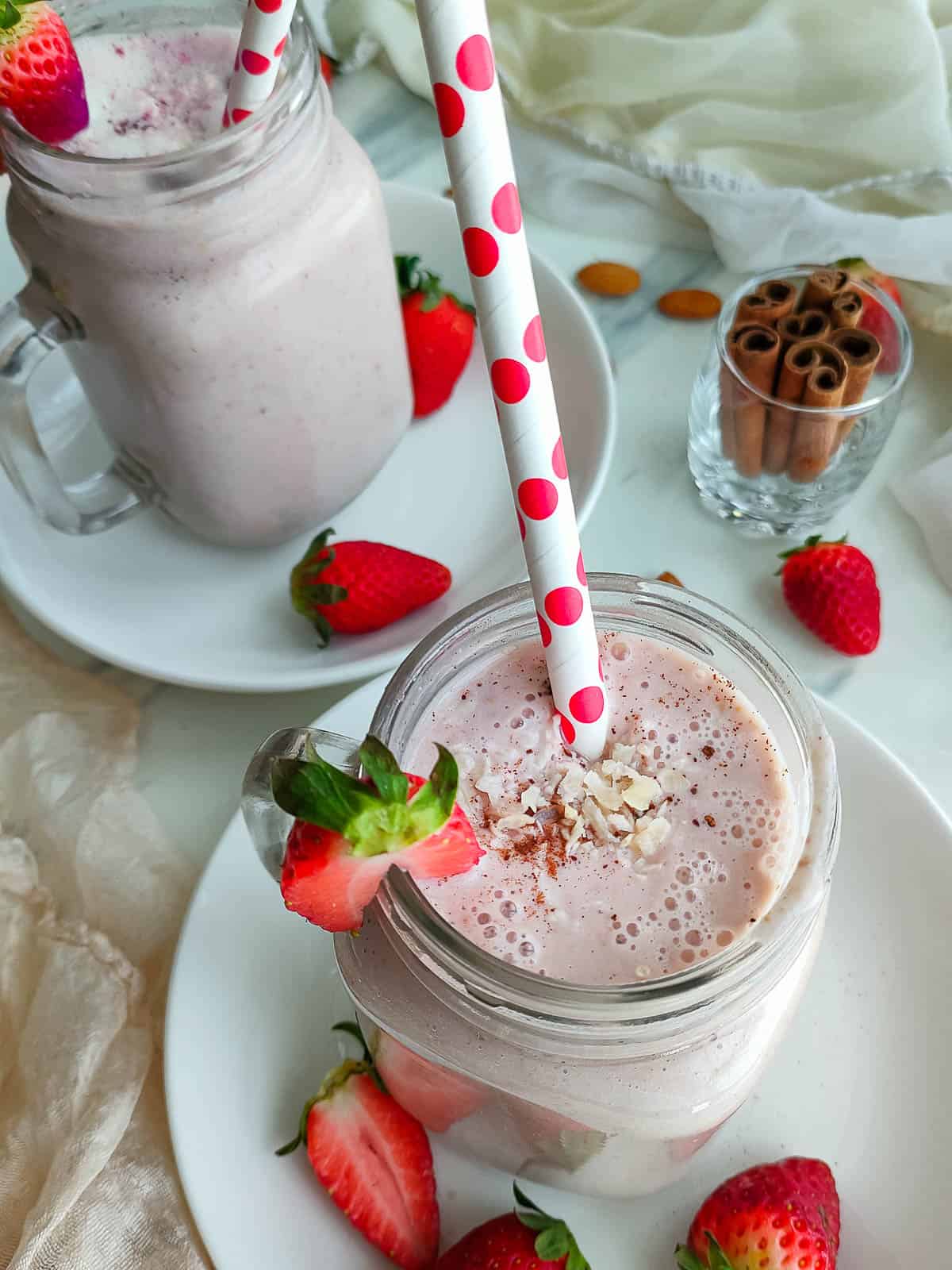 No-ice cream strawberry banana milkshake in 2 glass jars.