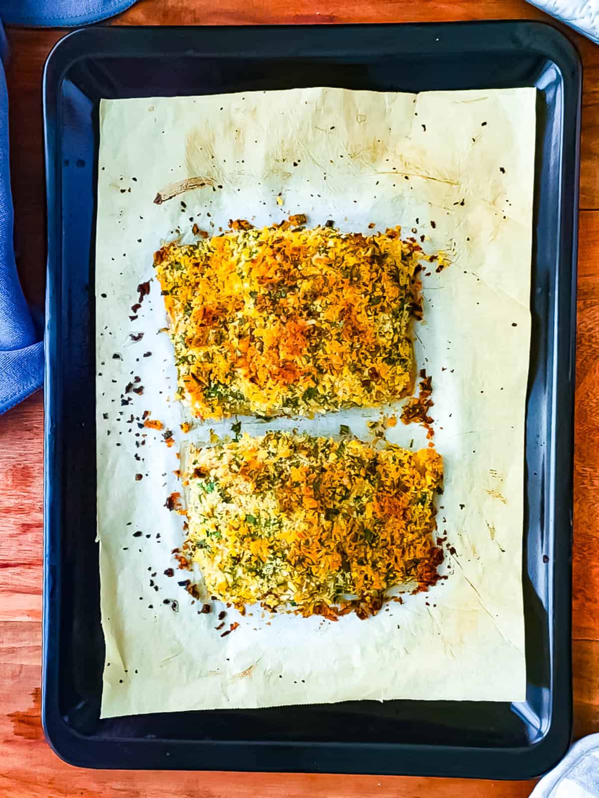 Baked fish with panko crumbs on a sheet pan.