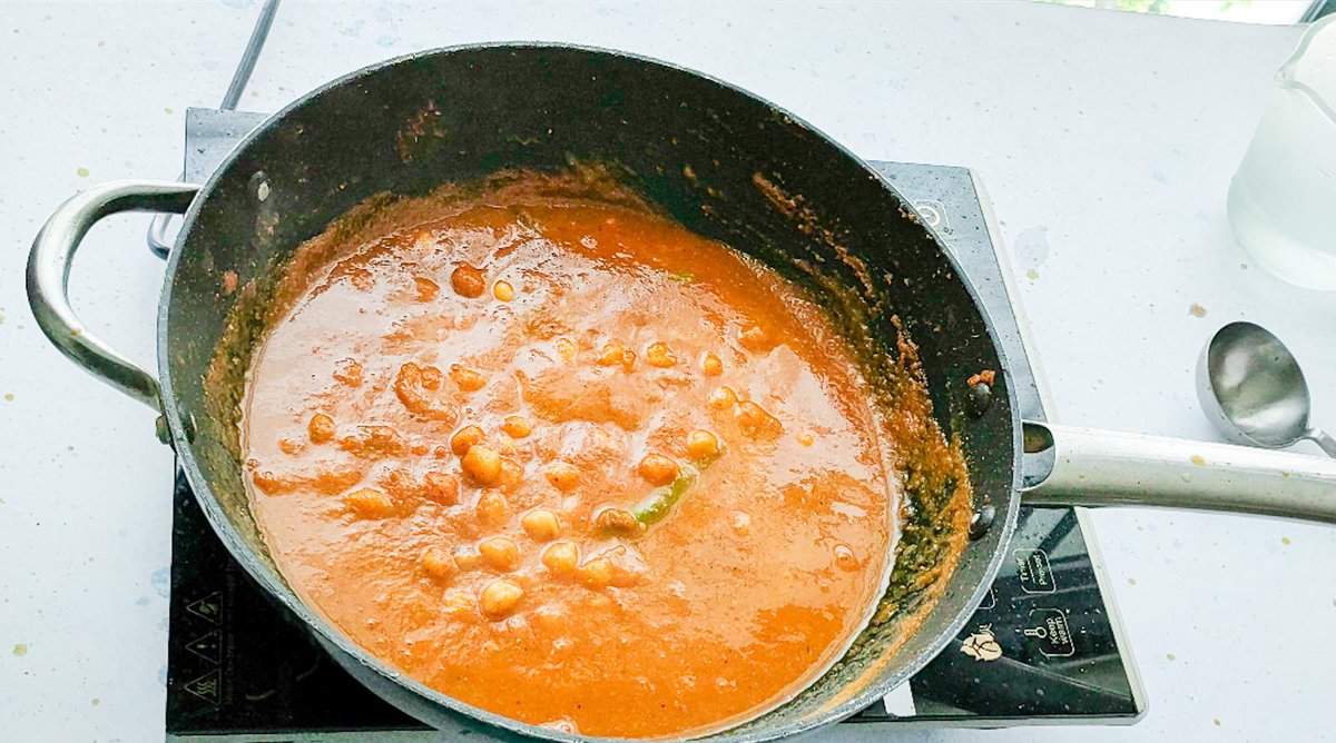 Simmering authentic chana masala in a non-stick wok.