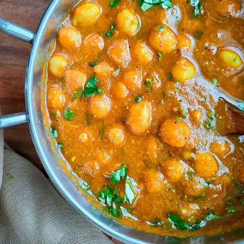 Closeup view of South Indian chickpea curry in a metal bowl.