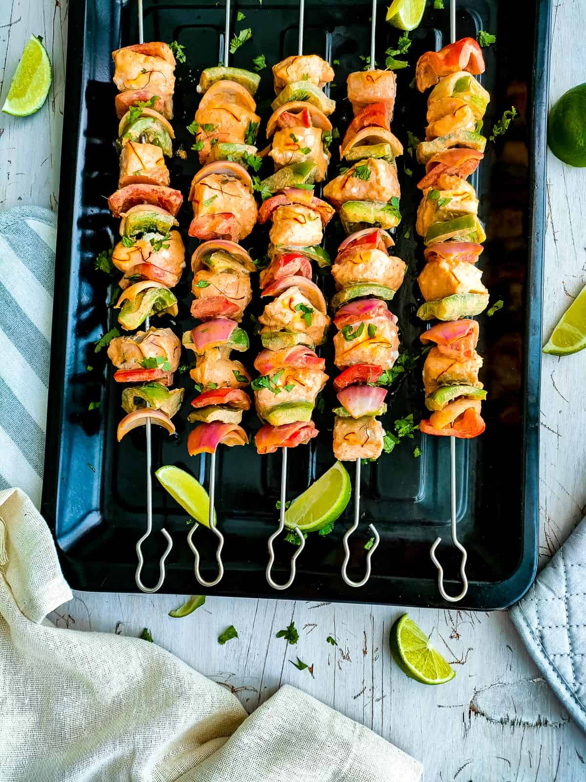 Spicy salmon bites with onions and peppers on a baking tray.