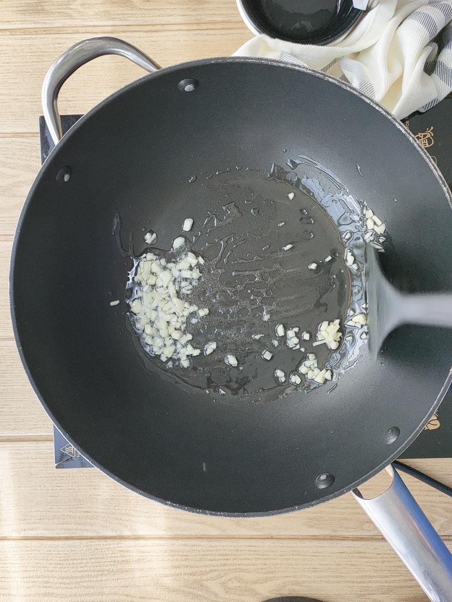 Garlic being stir-fried in a non-stick wok.