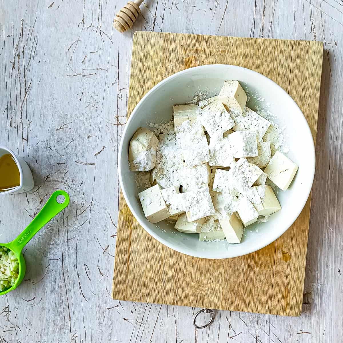 corn flour and seasoning added to tofu for pan frying.