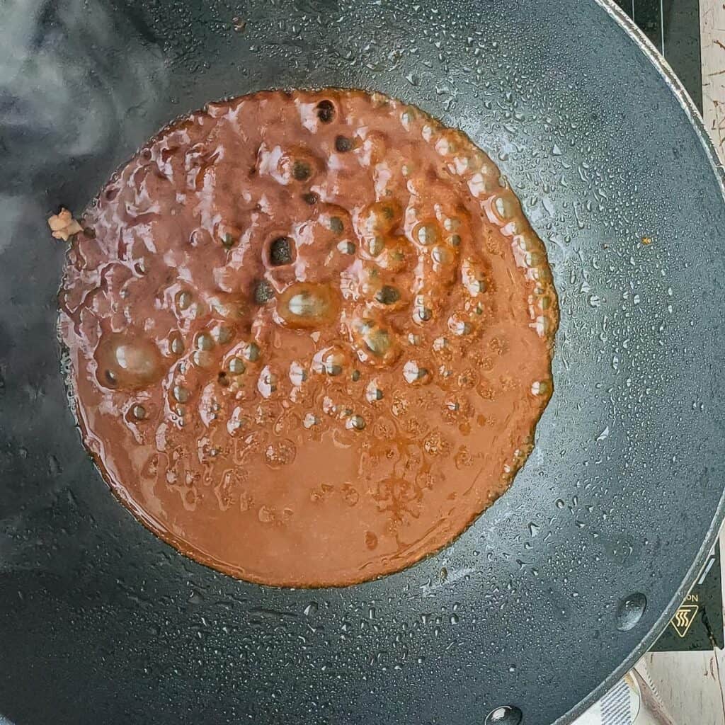 sauce simmering in a pan for lemon balsamic chicken.