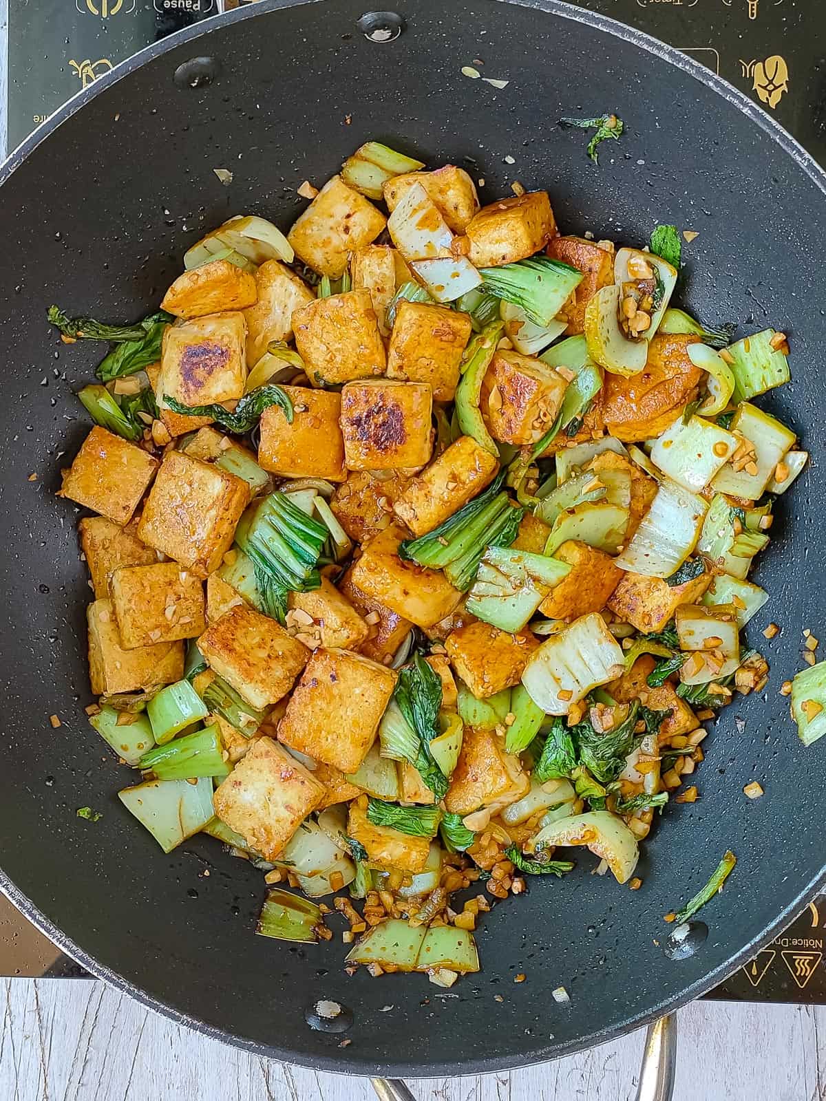 bok choy stir fry with tofu in a non-stick pan.