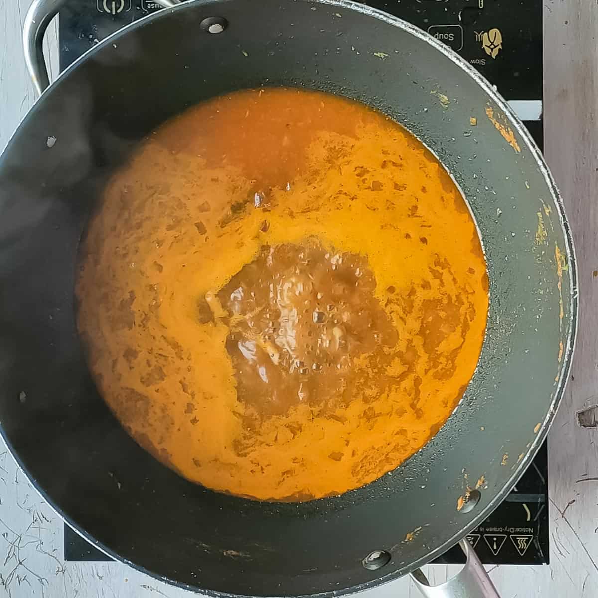 Curry boiling in a non-stick pan before adding chicken kofta..