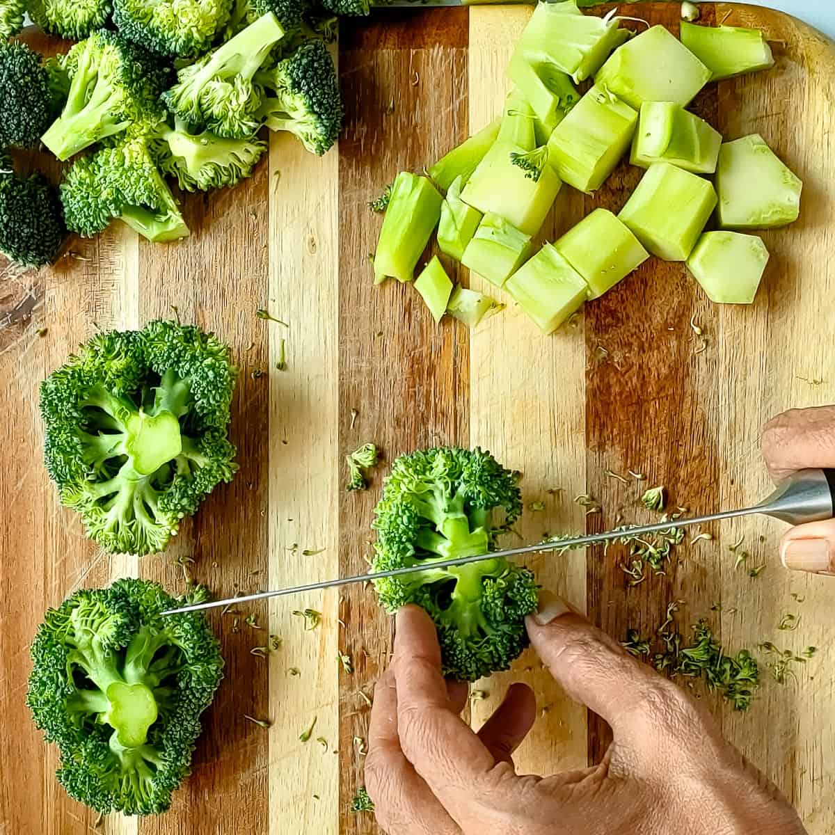 broccoli head being chopped for roasted potatoes and broccoli.