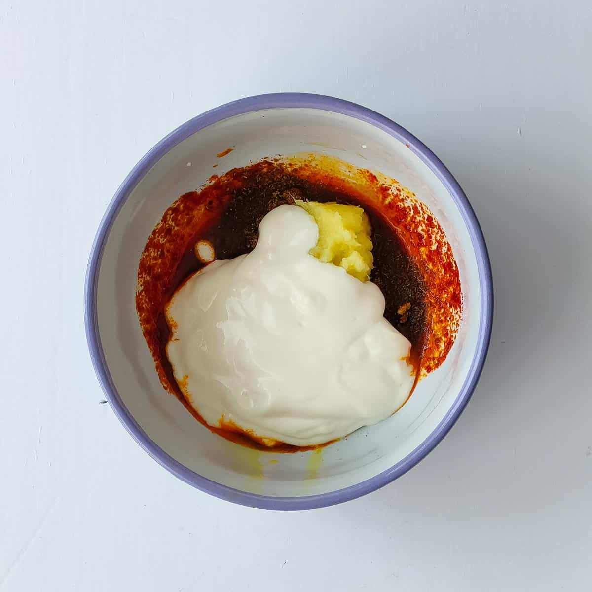 Easy Tandoori Chicken Tikka yogurt being added to tandoori chicken tikka marinade.