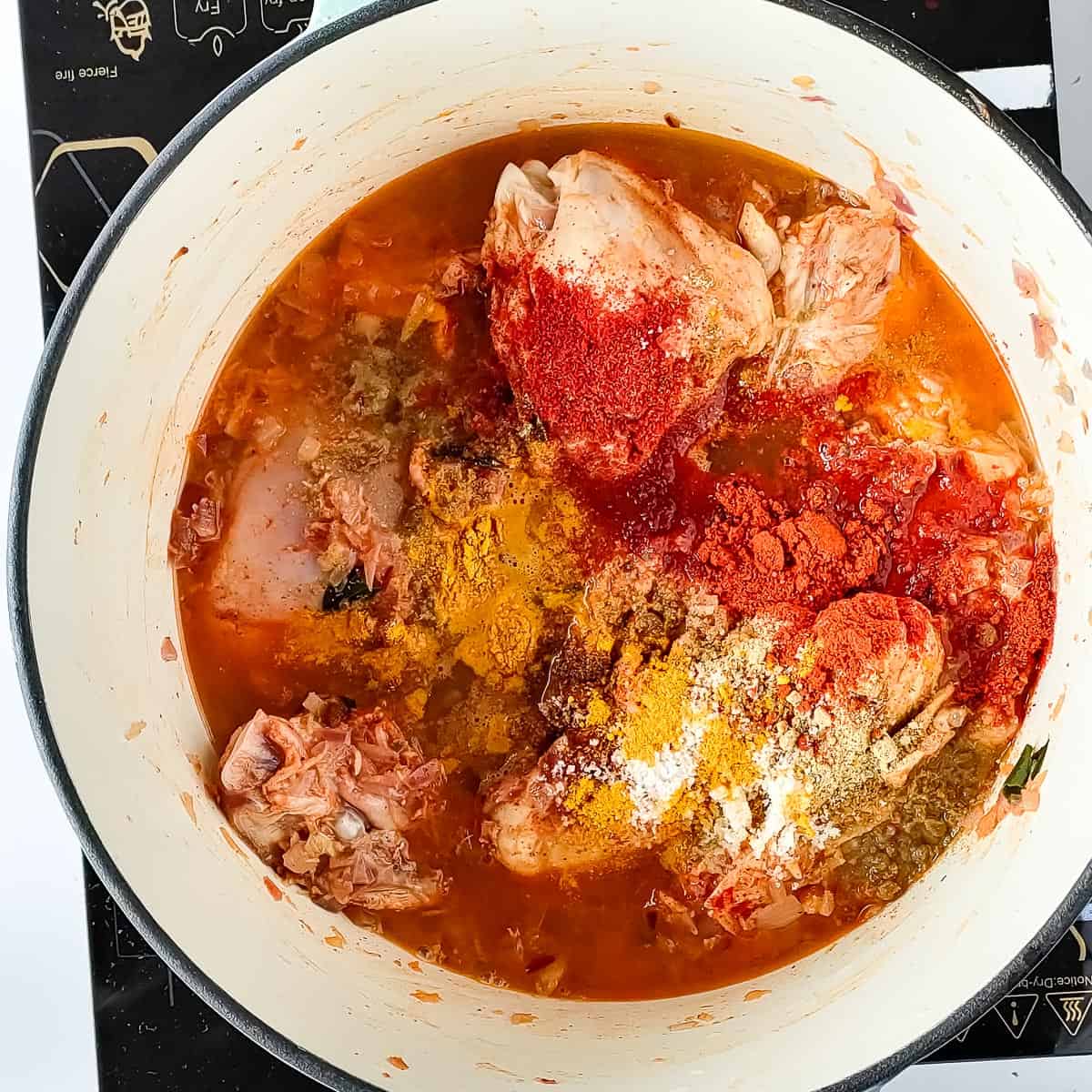 Spices being sauteed in a cooking pot for nadan kozhi curry