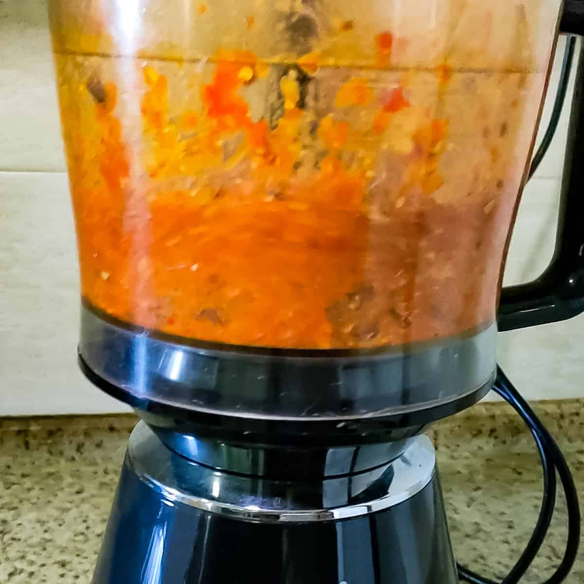 Chilli and garlic pesto being blended in a food processor.