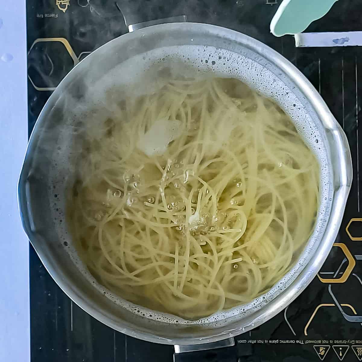 Spaghetti boiling in a pot.