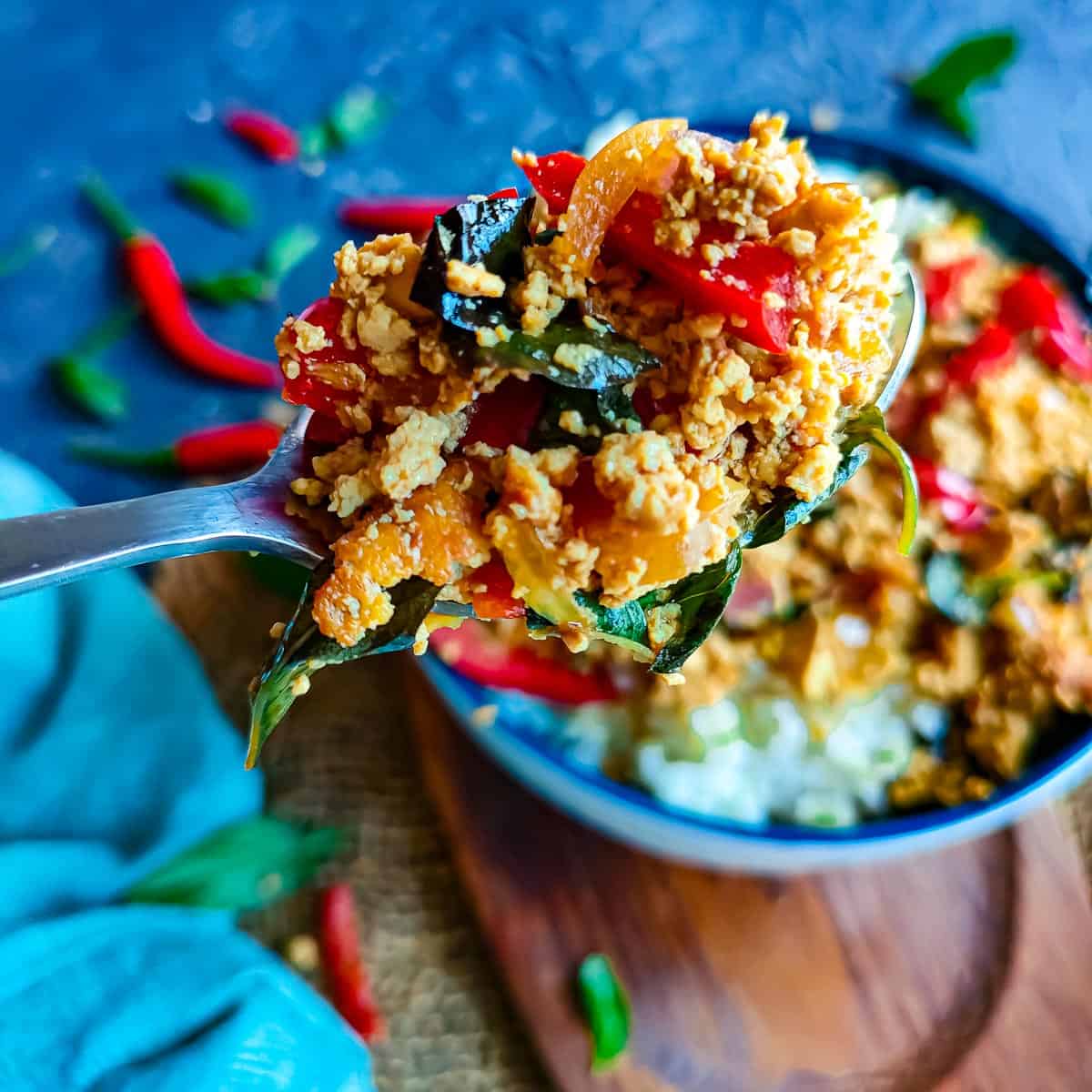 Easy Thai Basil Tofu Stir fry Thai basil tofu served with rice in a blue bowl.