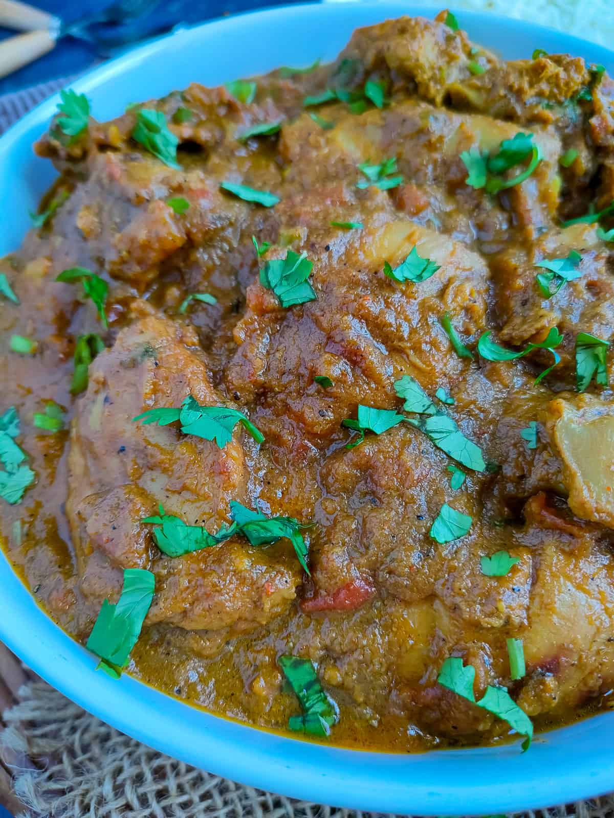 Pepper chicken curry in a white bowl.