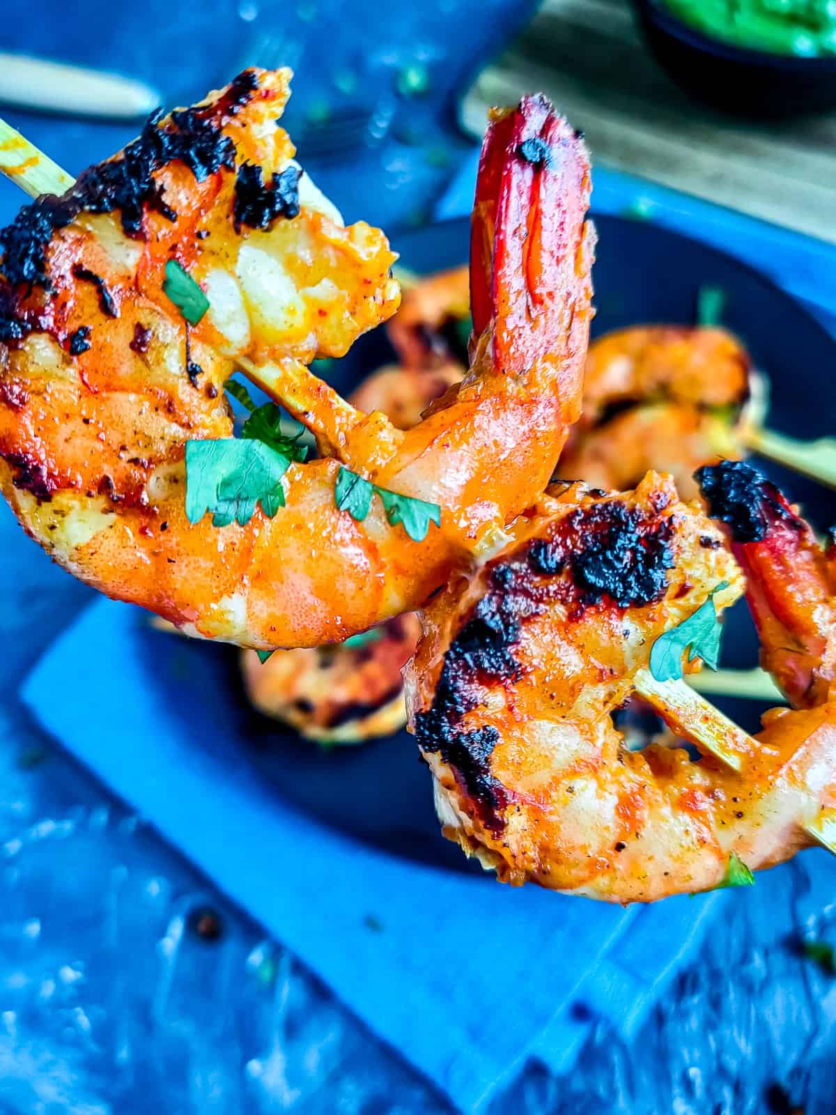 Tandoori king prawns on wooden skewers.