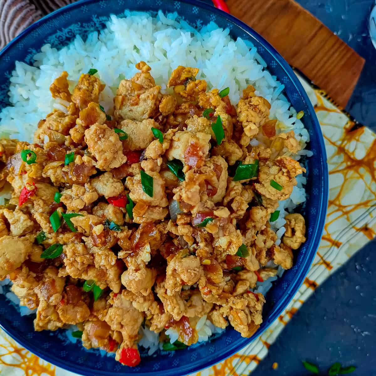 Ground chicken stir fry with rice in a blue bowl.