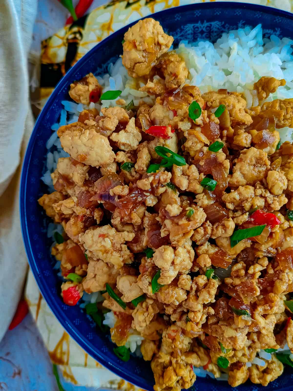 Ground chicken stir fry with rice in a blue bowl.