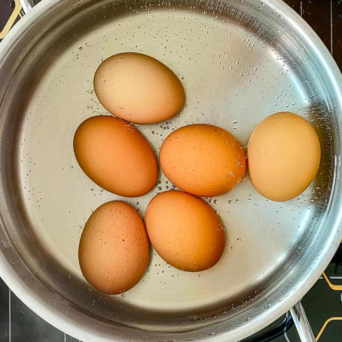 Boiled eggs in a metal pot.