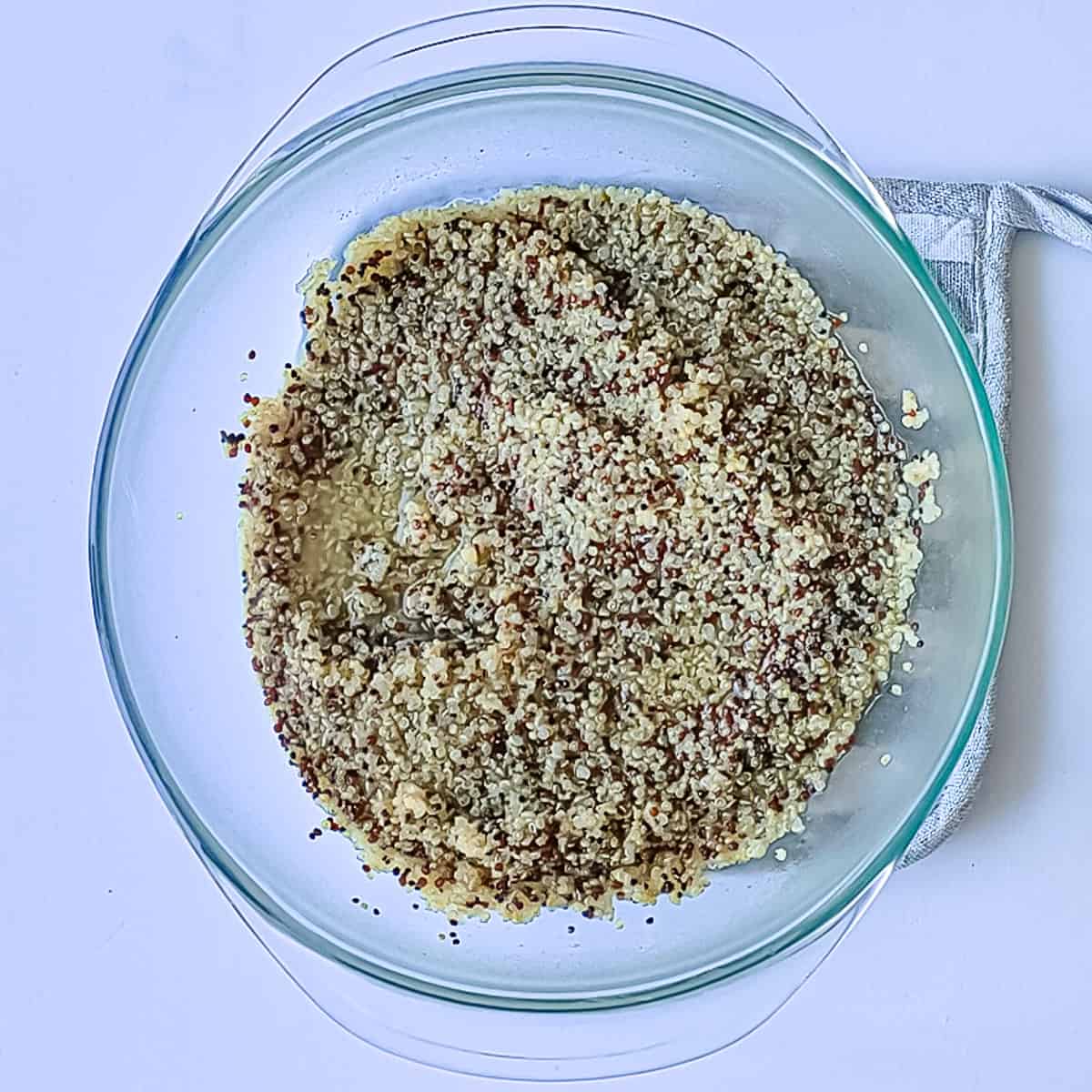 Half-cooked quinoa in a glass bowl.