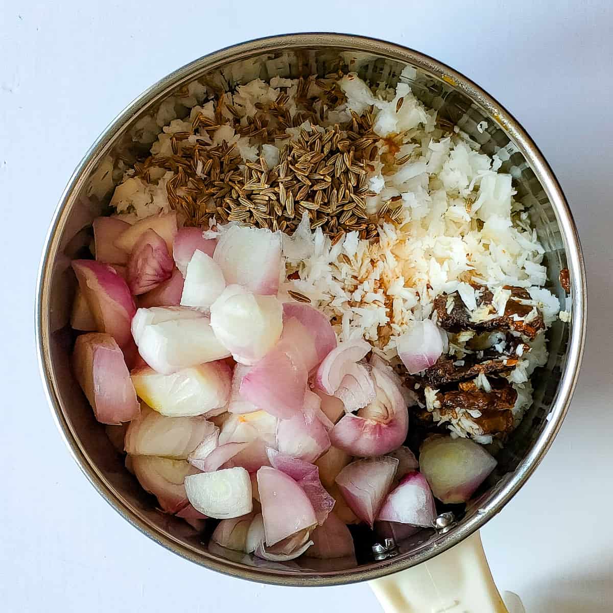 Ingredients for coconut onion paste in a blender jar.