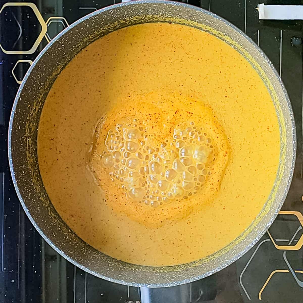 Coconut gravy simmering in a pot for fish curry.