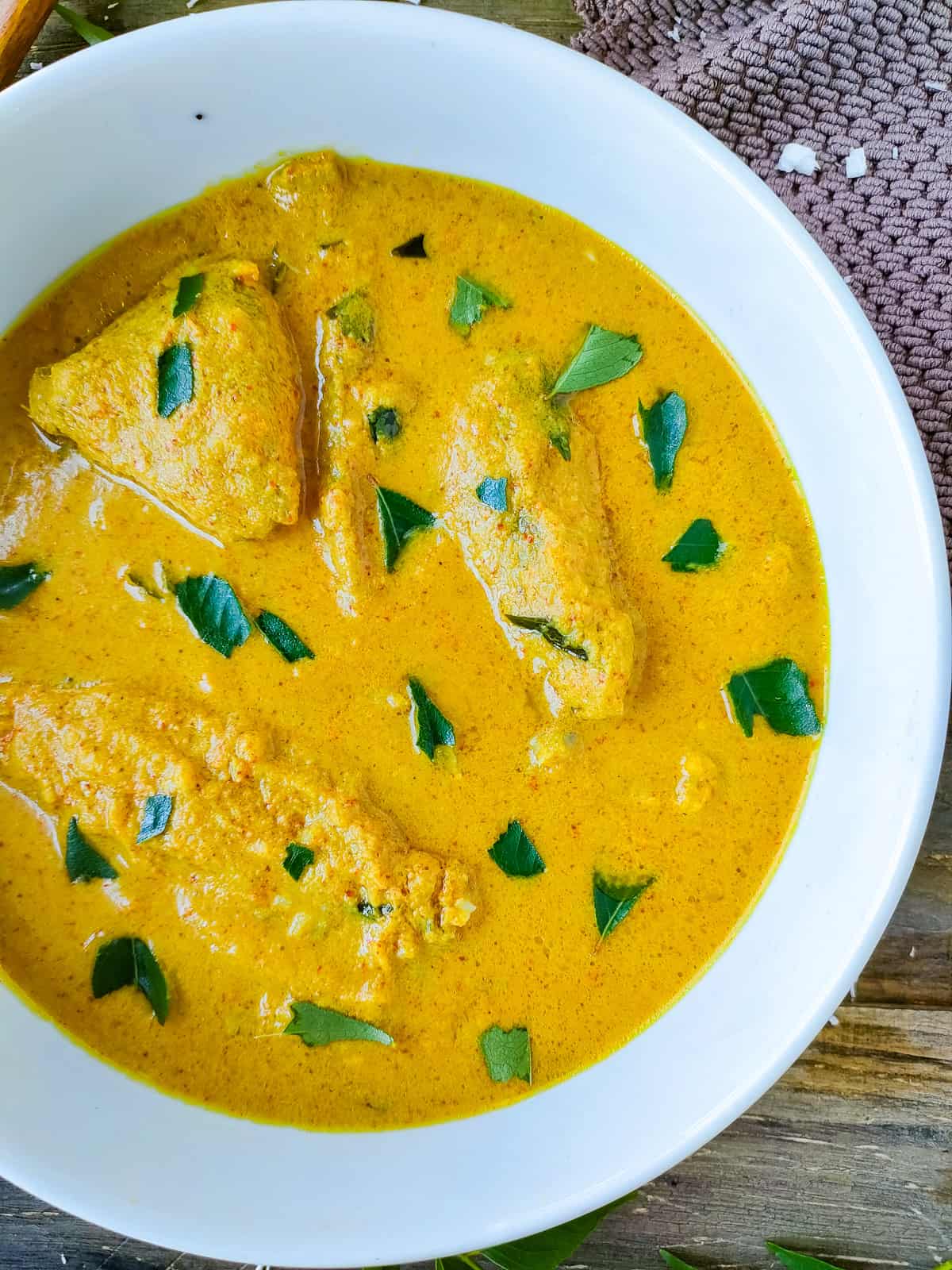Kerala meen curry in a white bowl.