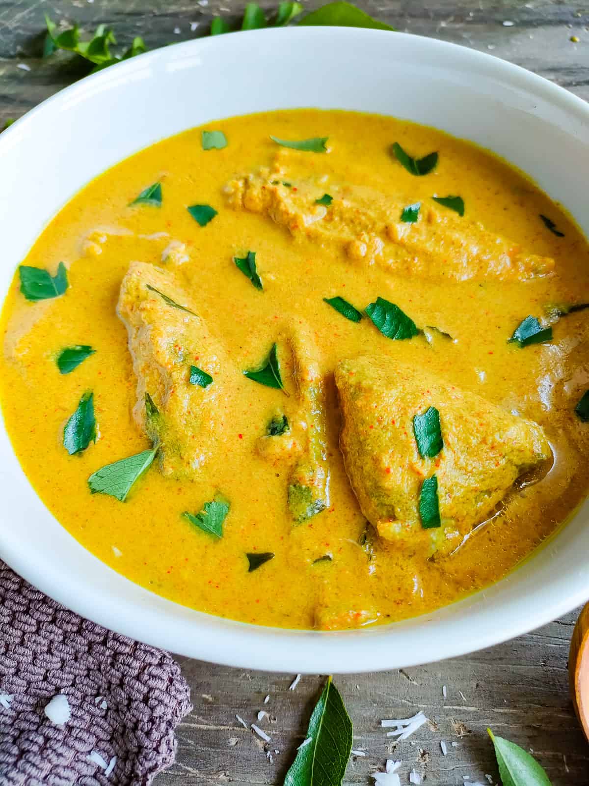 Kerala fish curry in a white bowl.
