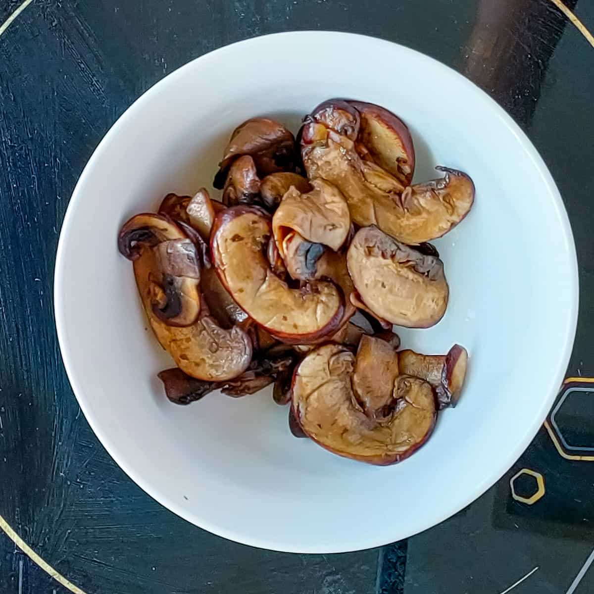 Sauteed mushrooms in a white bowl.